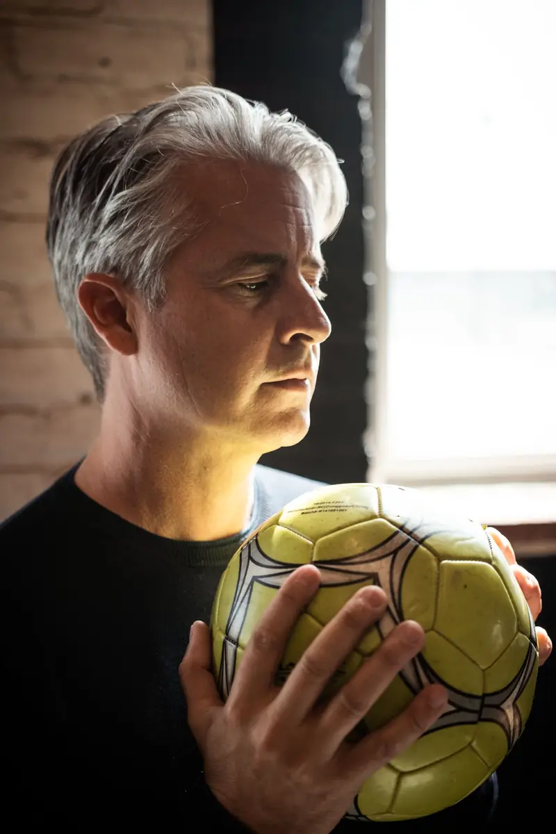 A coach holding a football